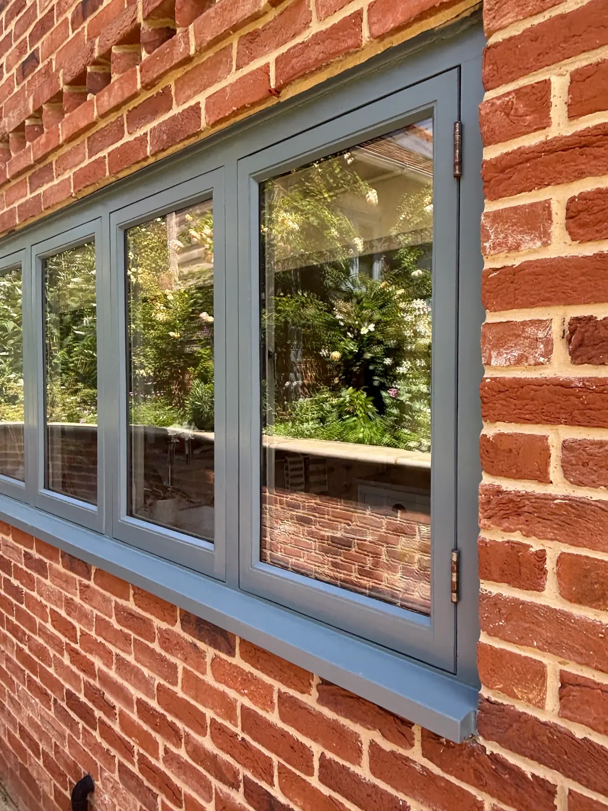 Slate grey painted window frames on a red brick exterior